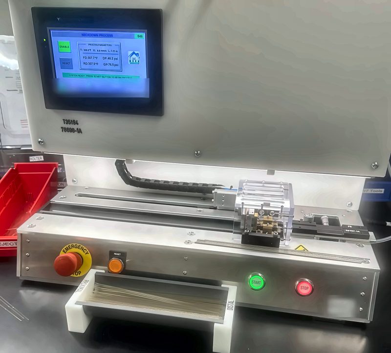 Benchtop neckdown machine built by Walkers Automation, with touchscreen controls and a guarded die station