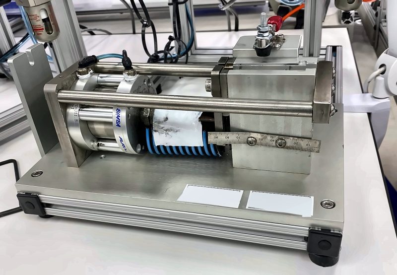 Benchtop pneumatic press station on an aluminum frame with stainless guide rods and a setup scale